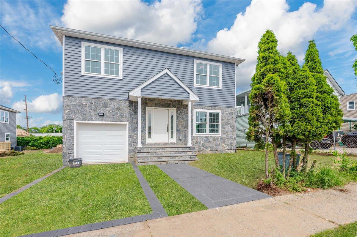 View of front of house with a garage and a front lawn