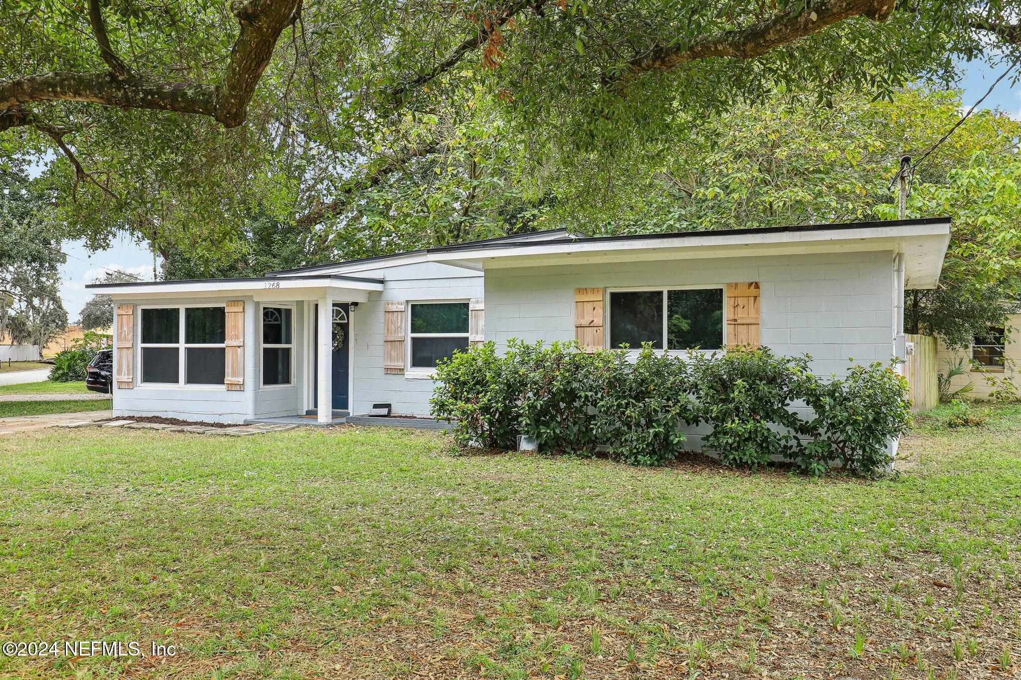 a house that has a big yard with large trees