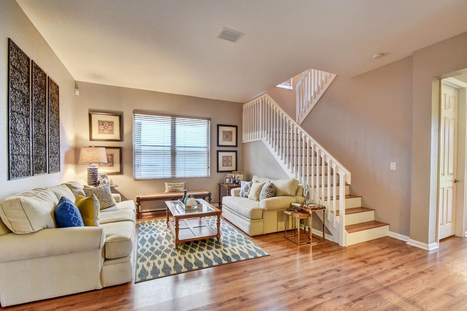 a living room with furniture and a wooden floor