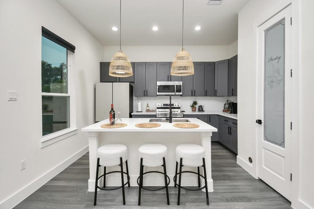 a kitchen with kitchen island stainless steel appliances a dining table and chairs