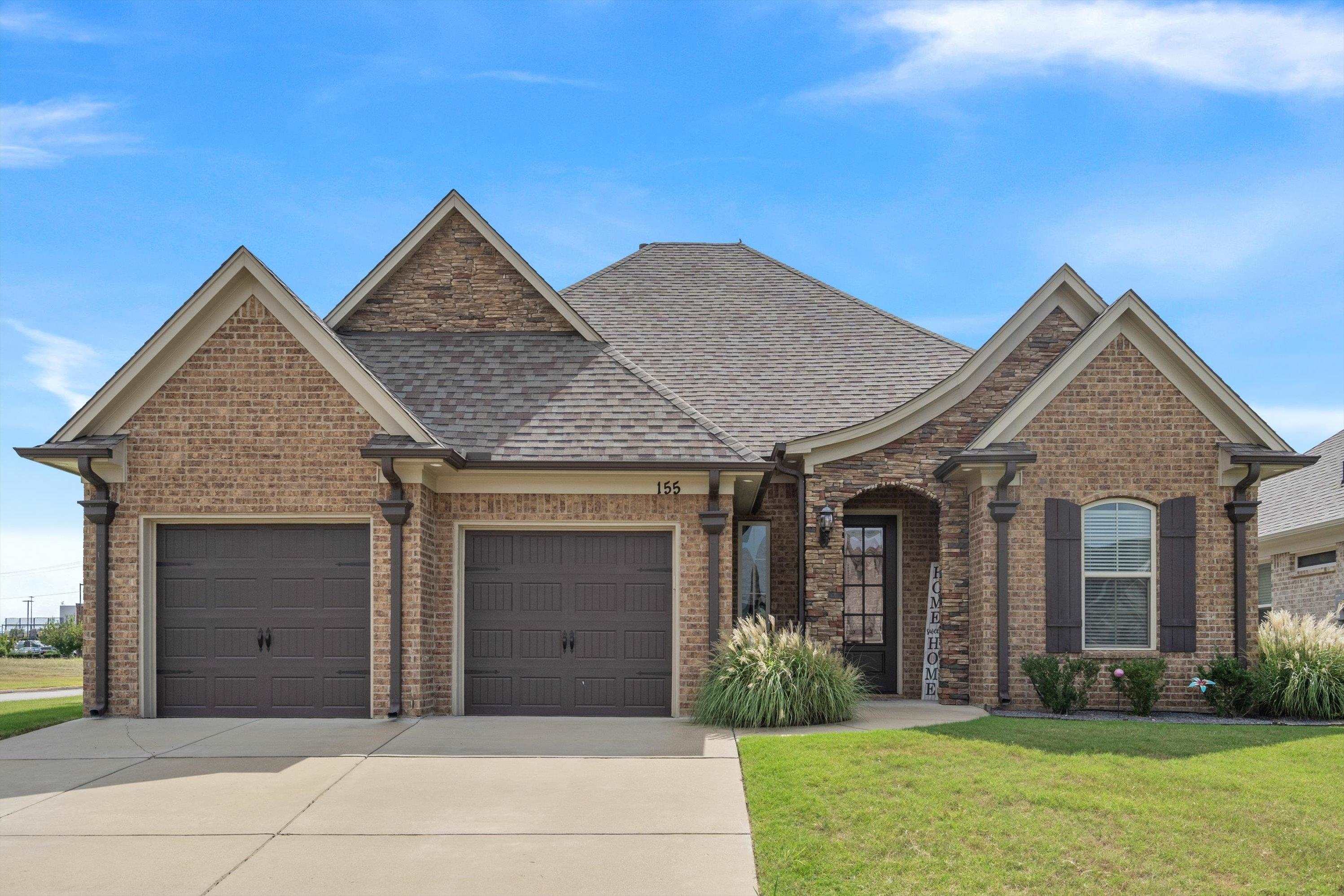 View of front of property with a garage and a front lawn