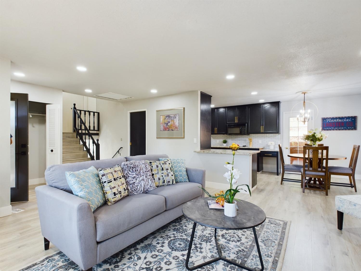 a living room with furniture and a view of kitchen