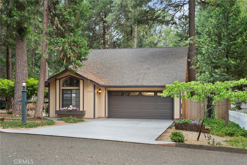 front view of a house with a yard and an trees