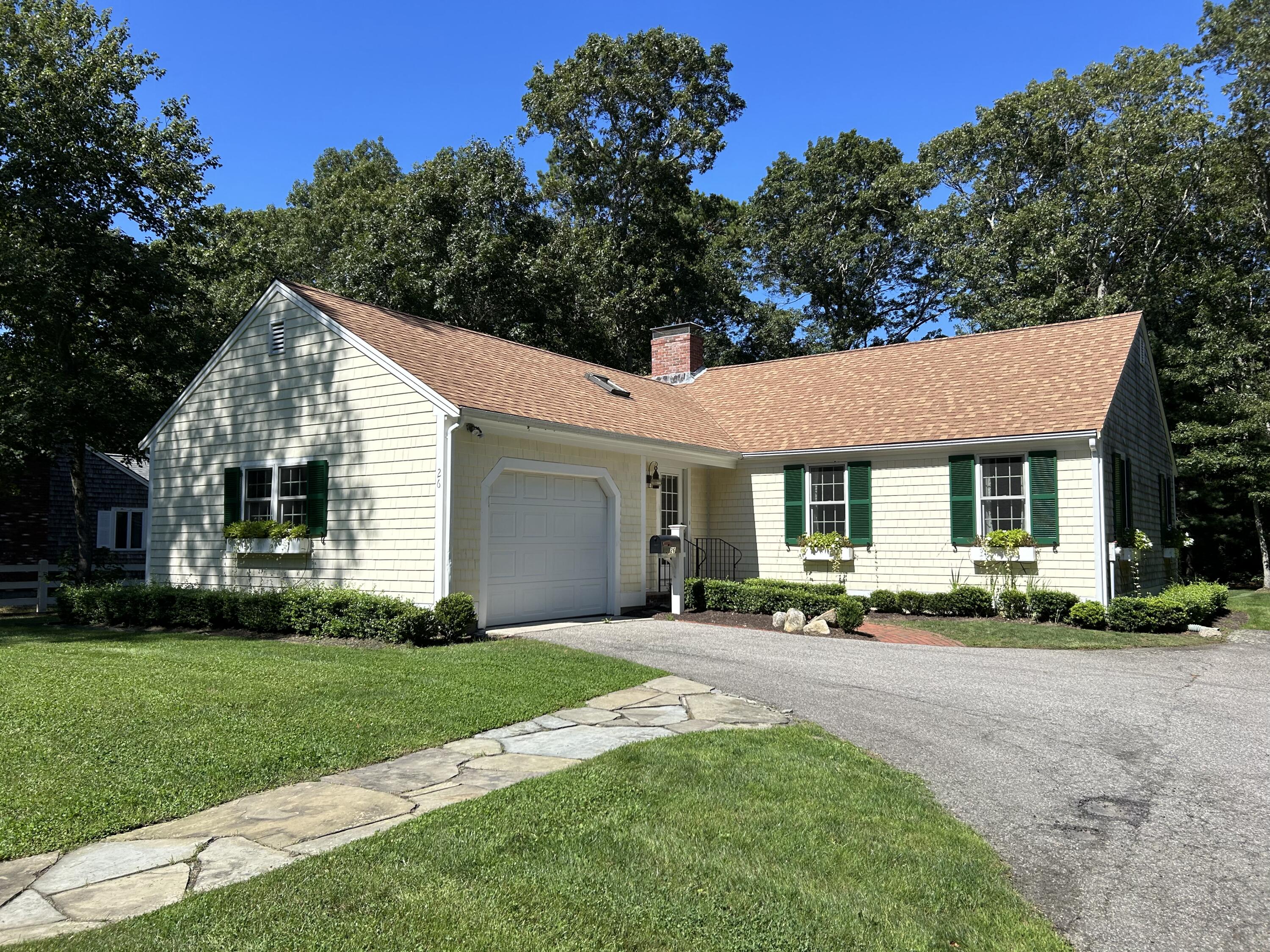 a front view of house with yard and green space