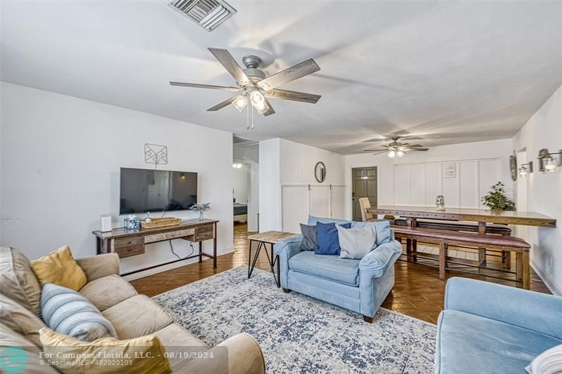 a living room with furniture kitchen view and a flat screen tv