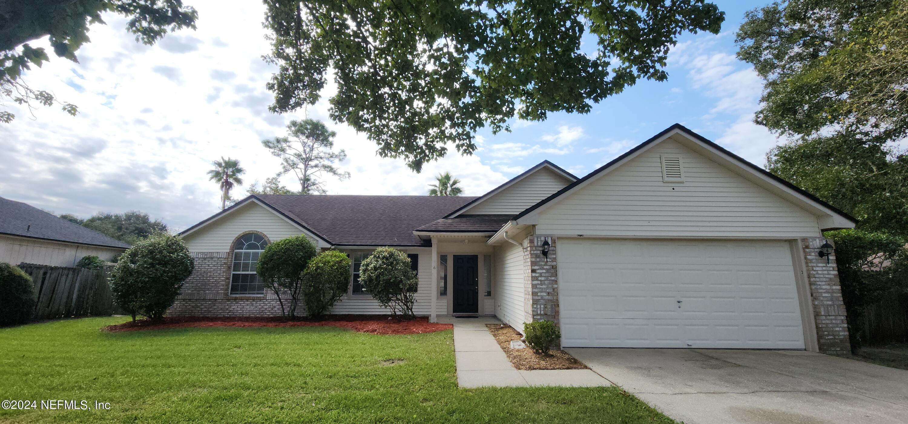 a front view of house with yard and garage