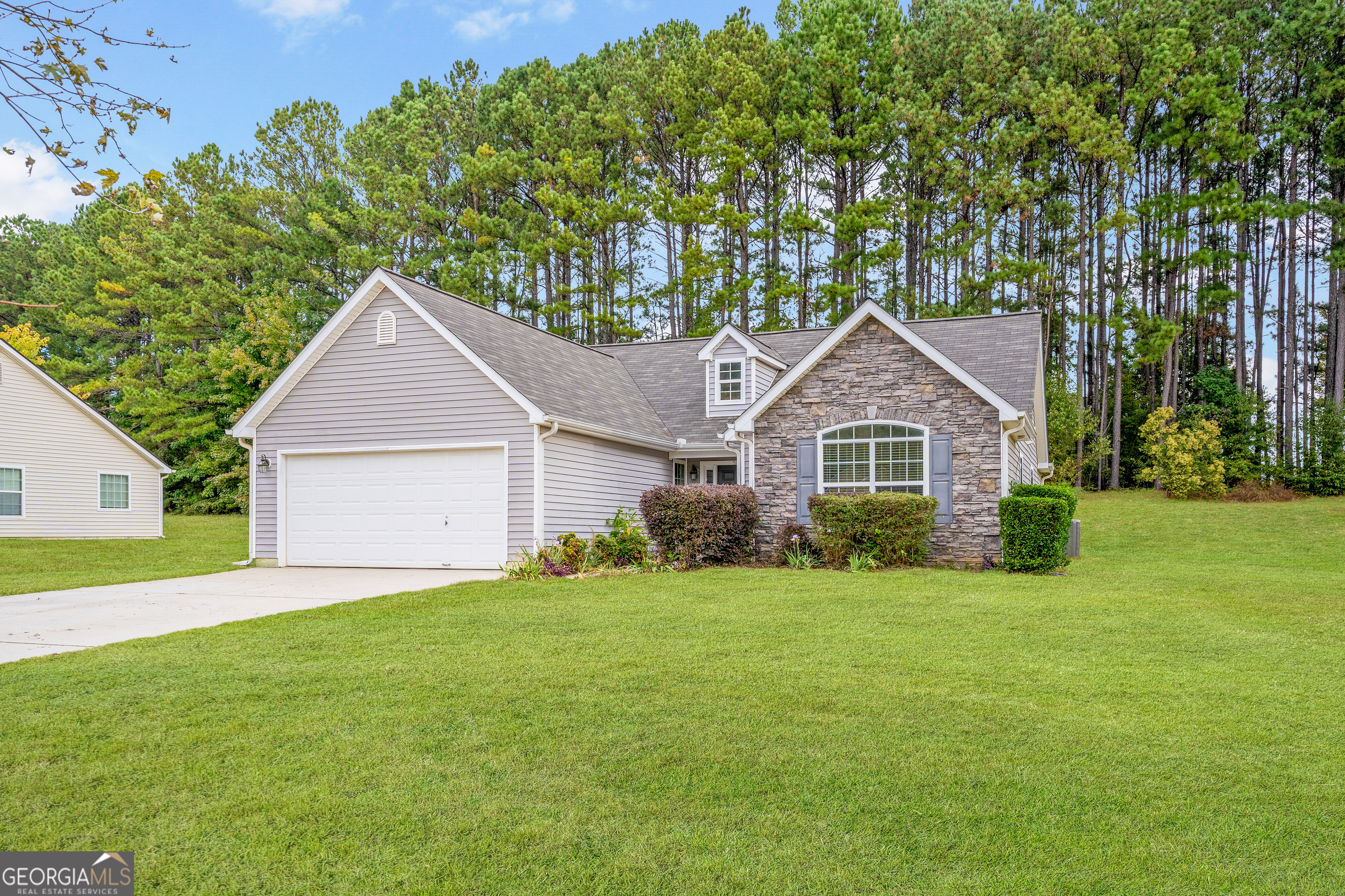 a front view of a house with yard and green space