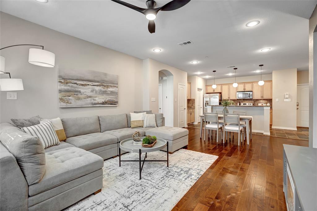 a living room with furniture and a dining table with wooden floor