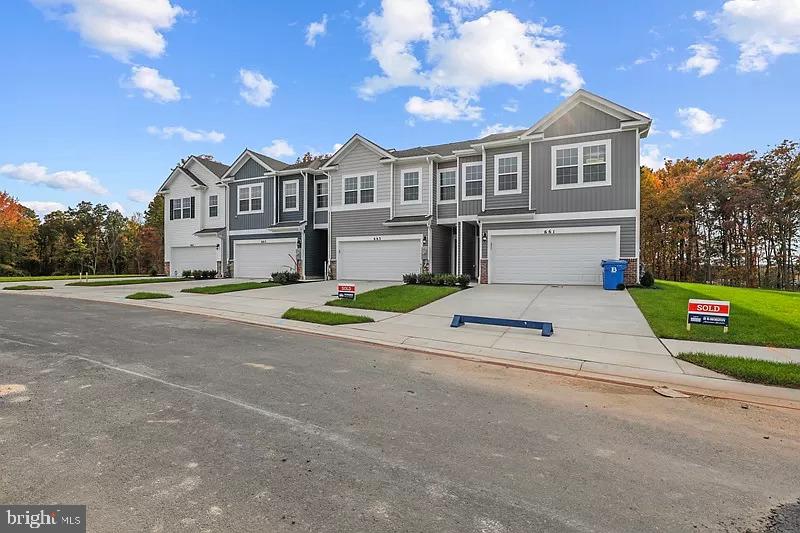 a view of a house with a yard and a garage