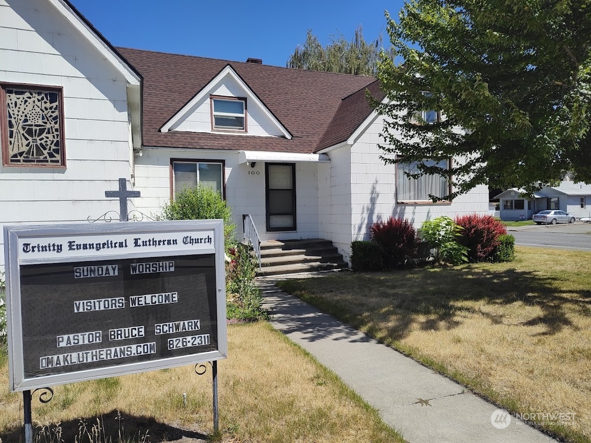 a view of a house with sign board and a yard