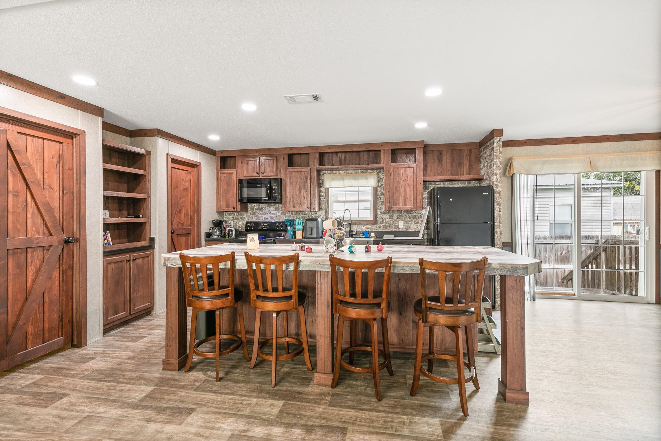 a dining hall with stainless steel appliances kitchen island granite countertop a dining table chairs and granite counter tops