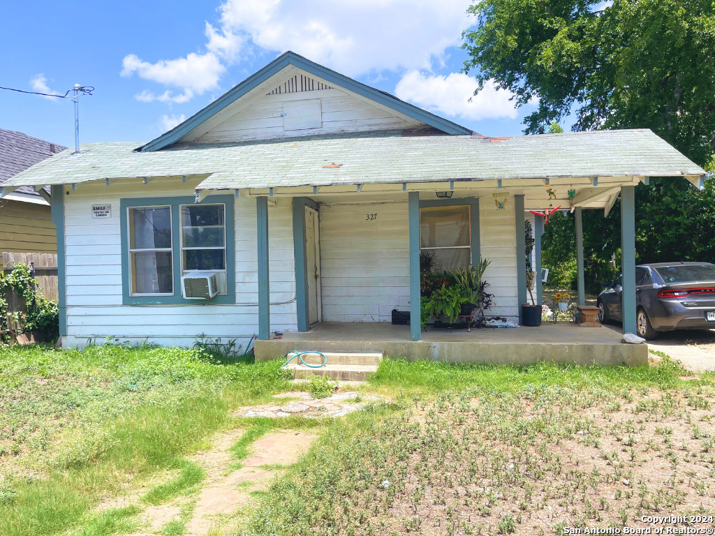 a view of a house with a yard and porch