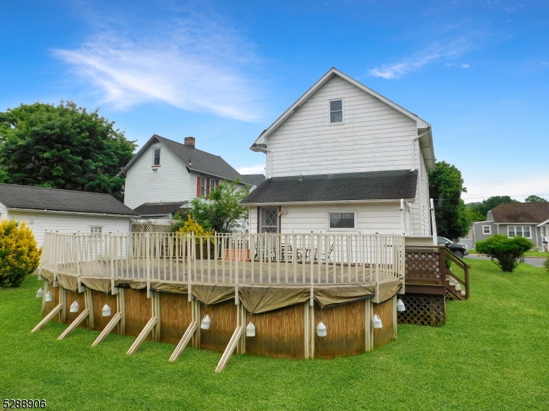 a view of backyard of house with deck and outdoor seating