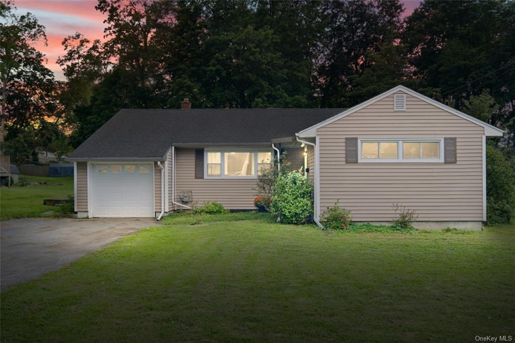 Ranch-style home with a lawn and a garage