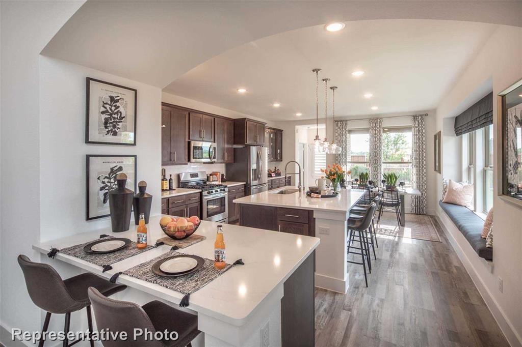 a view of a dining room with furniture a kitchen and chandelier