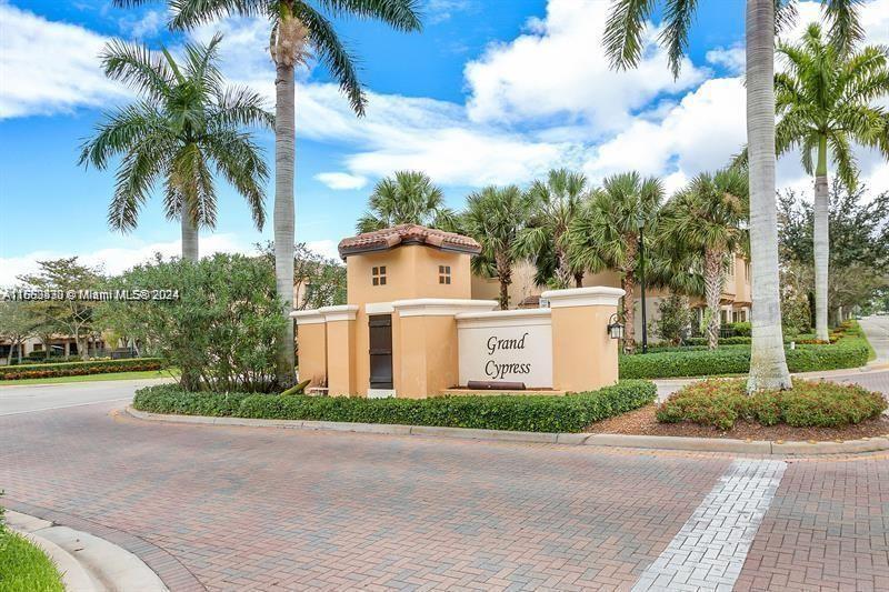 a view of a white house with a big yard and palm trees