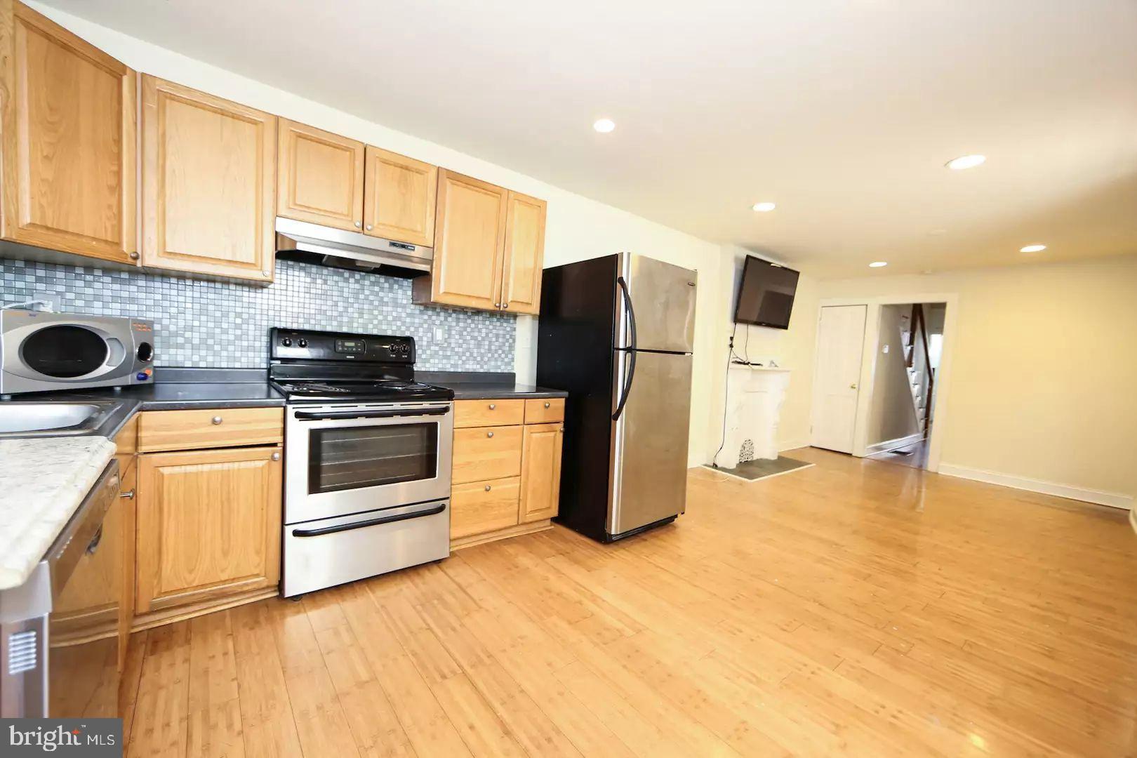 a kitchen with a refrigerator sink and stove top oven