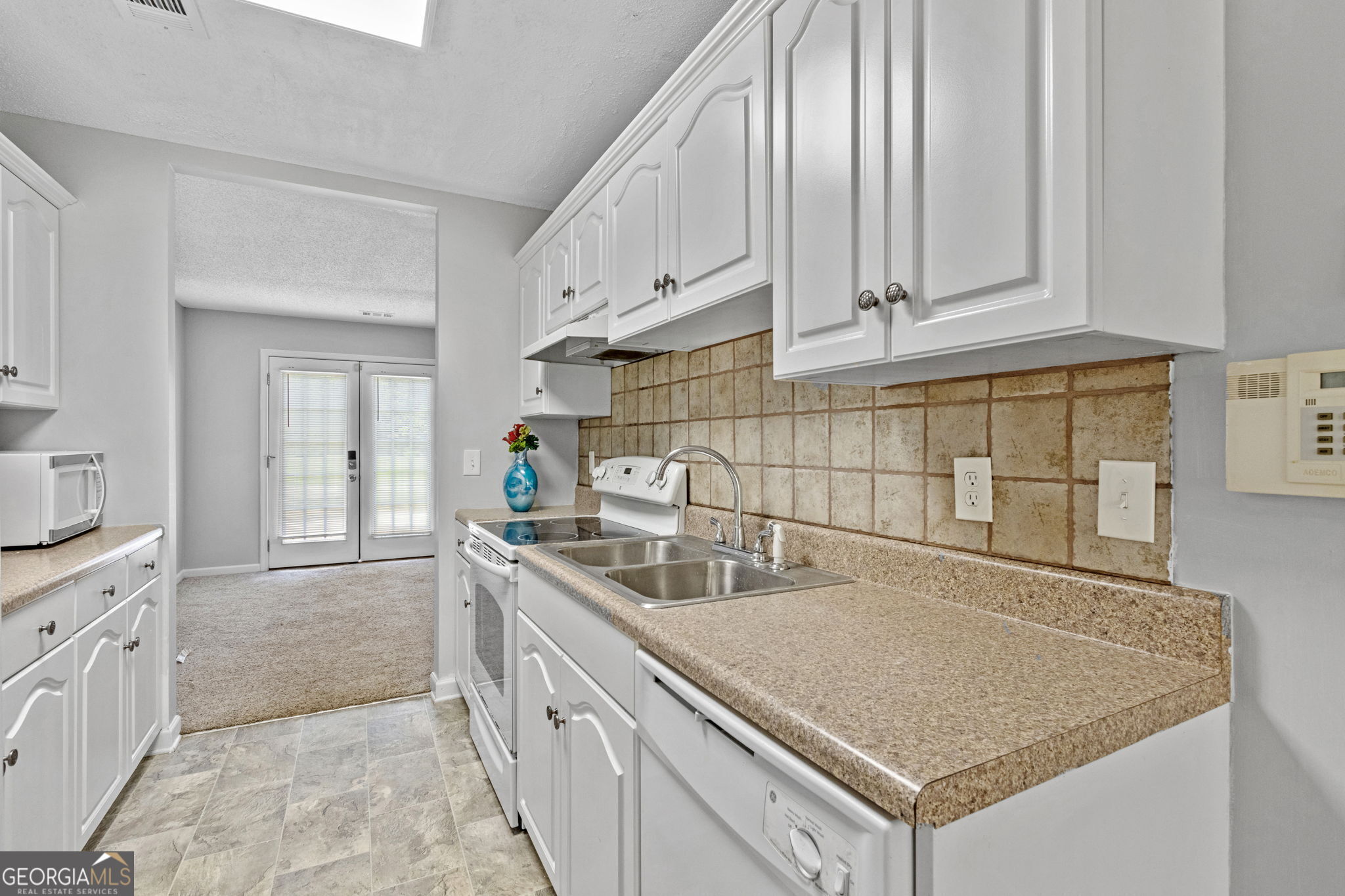 a kitchen with stainless steel appliances granite countertop a sink stove and cabinets