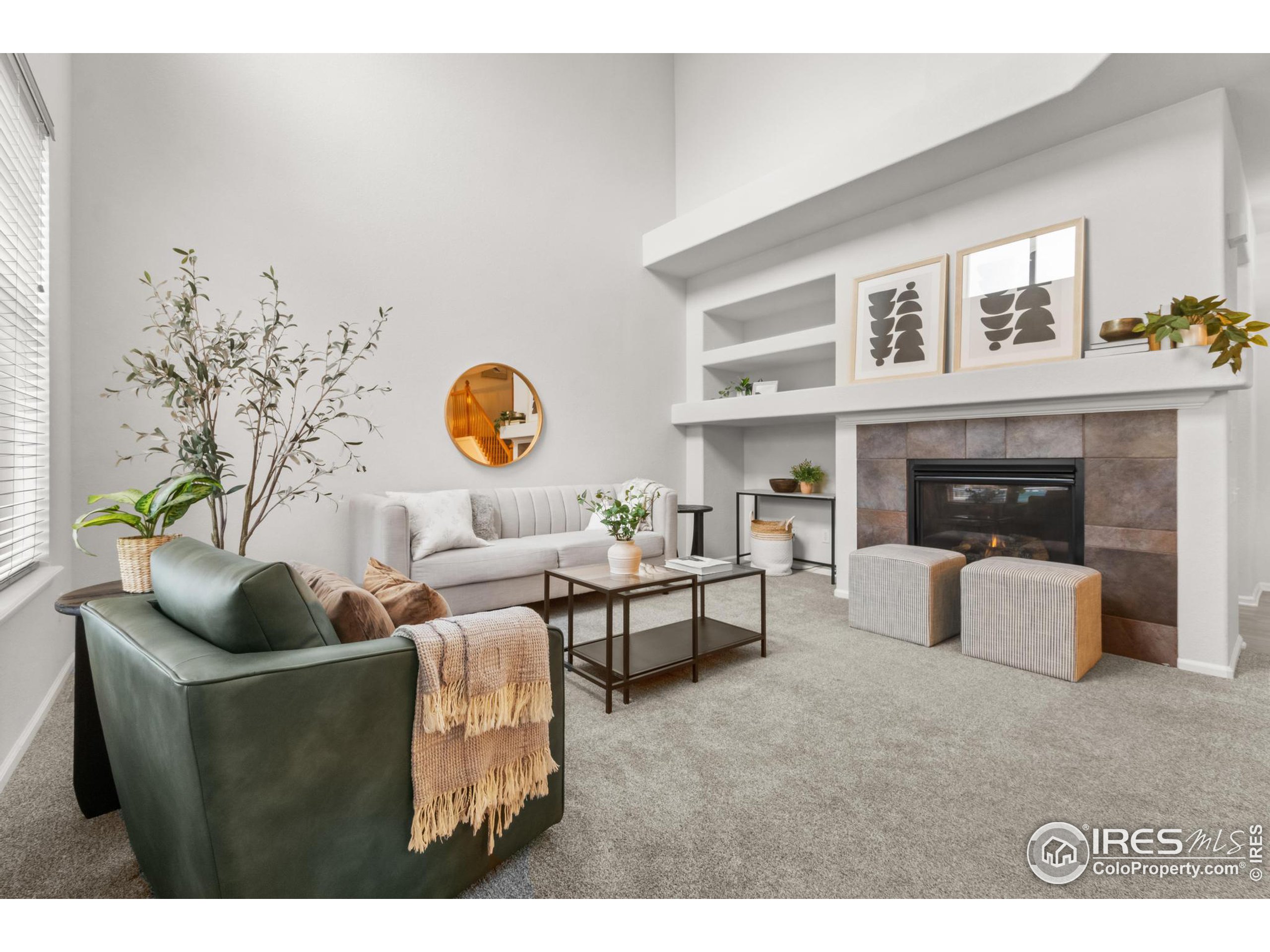 a living room with furniture a fireplace and a window