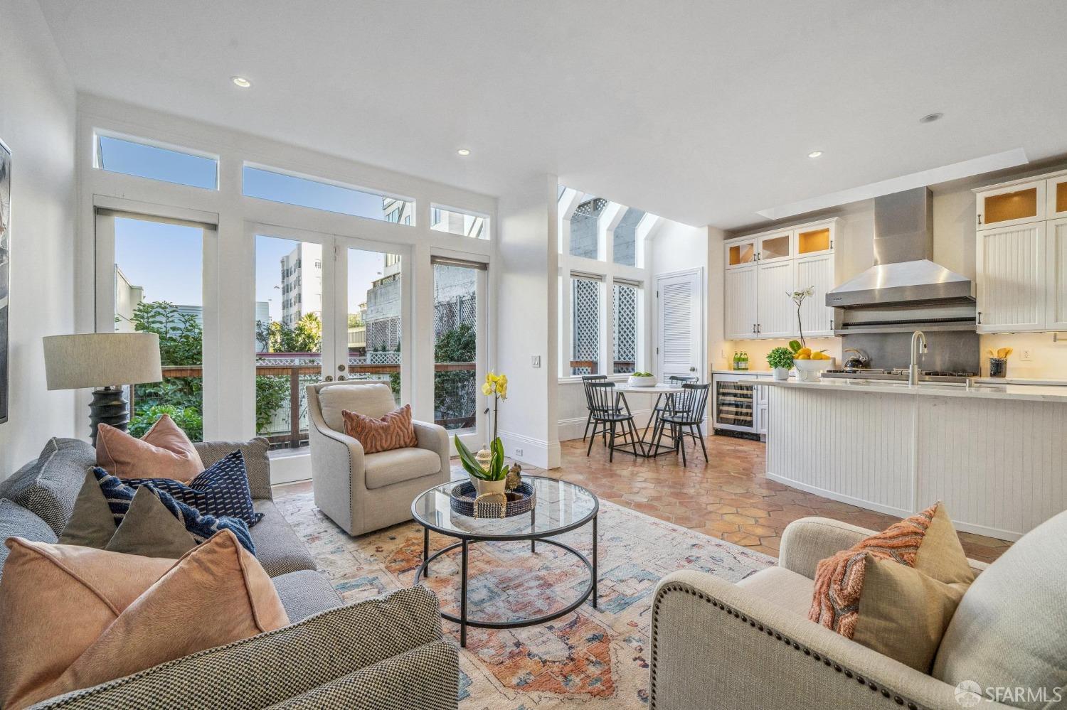 a living room with furniture kitchen view and large windows