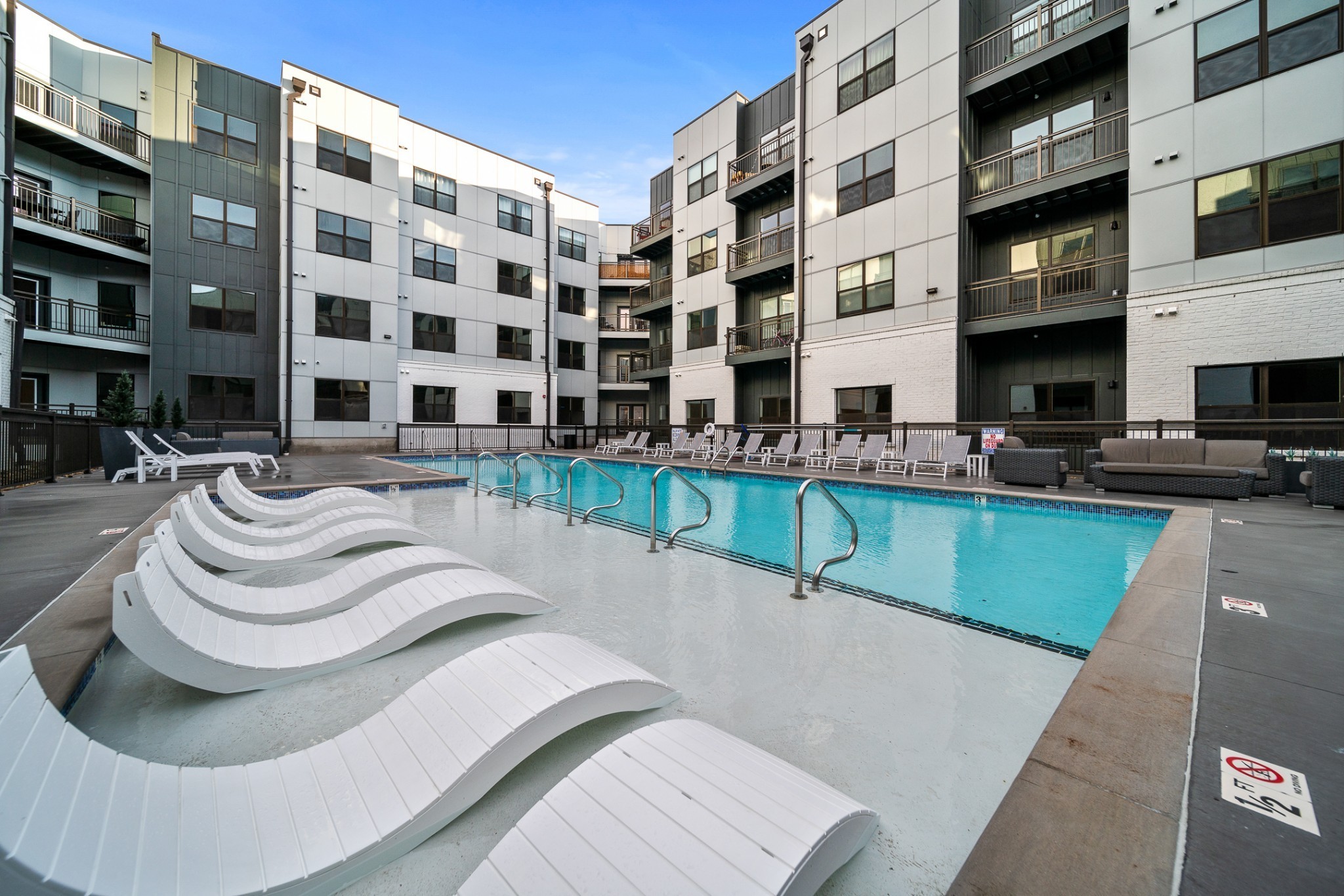 a swimming pool with outdoor seating and a yard