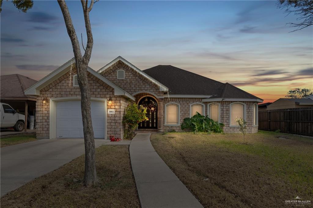 Ranch-style house featuring a yard and a garage