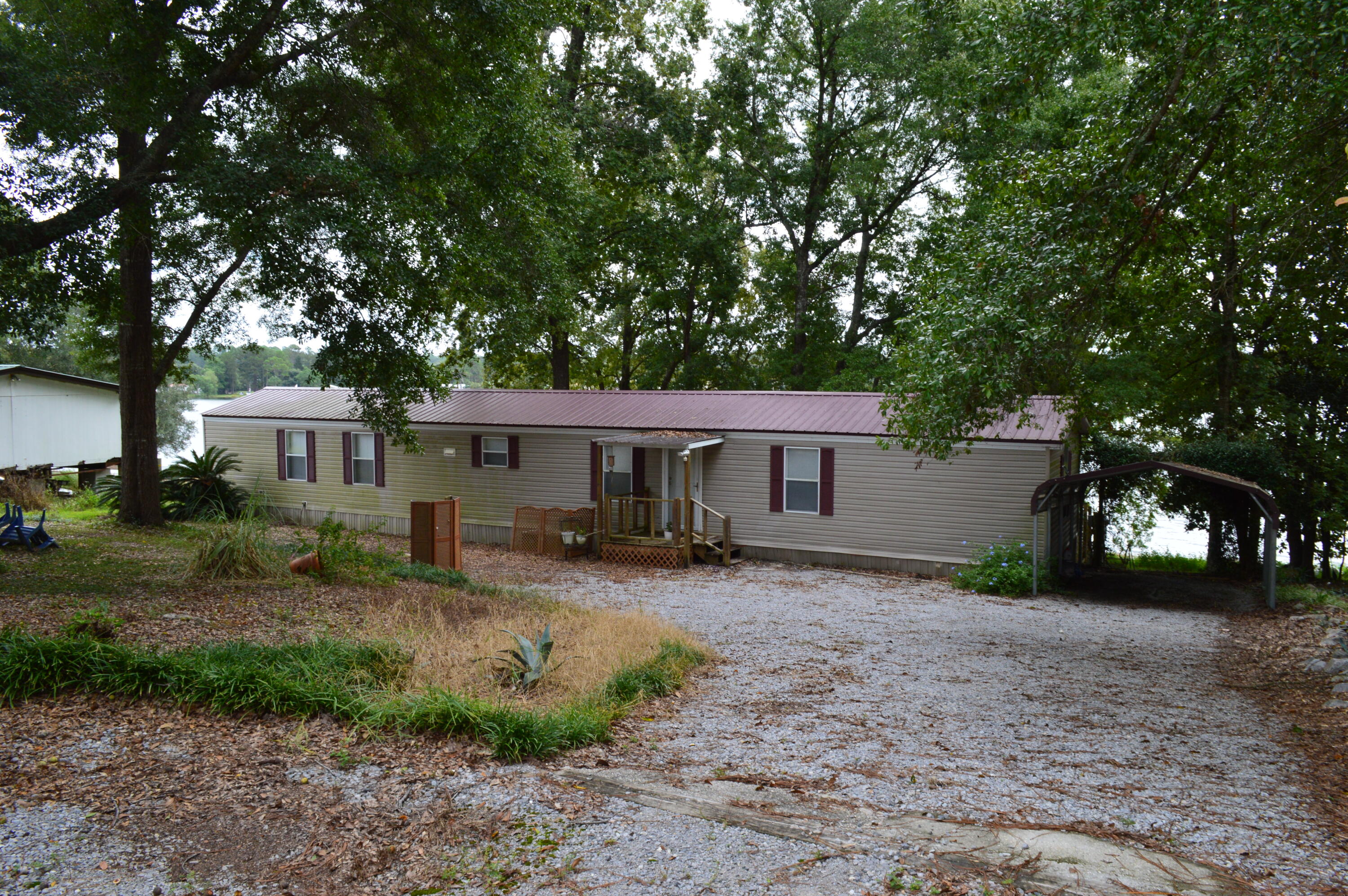 a view of a house with a yard tree and a wooden fence