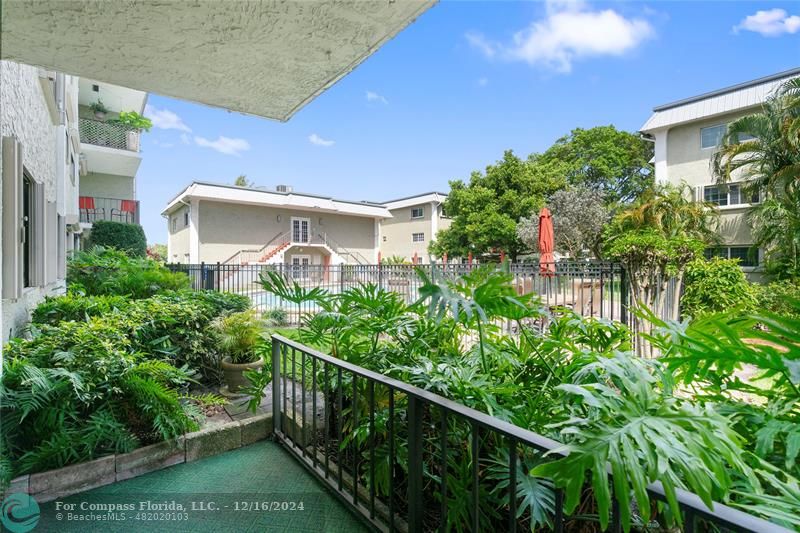 Private porch with lush foliage opposite pool area