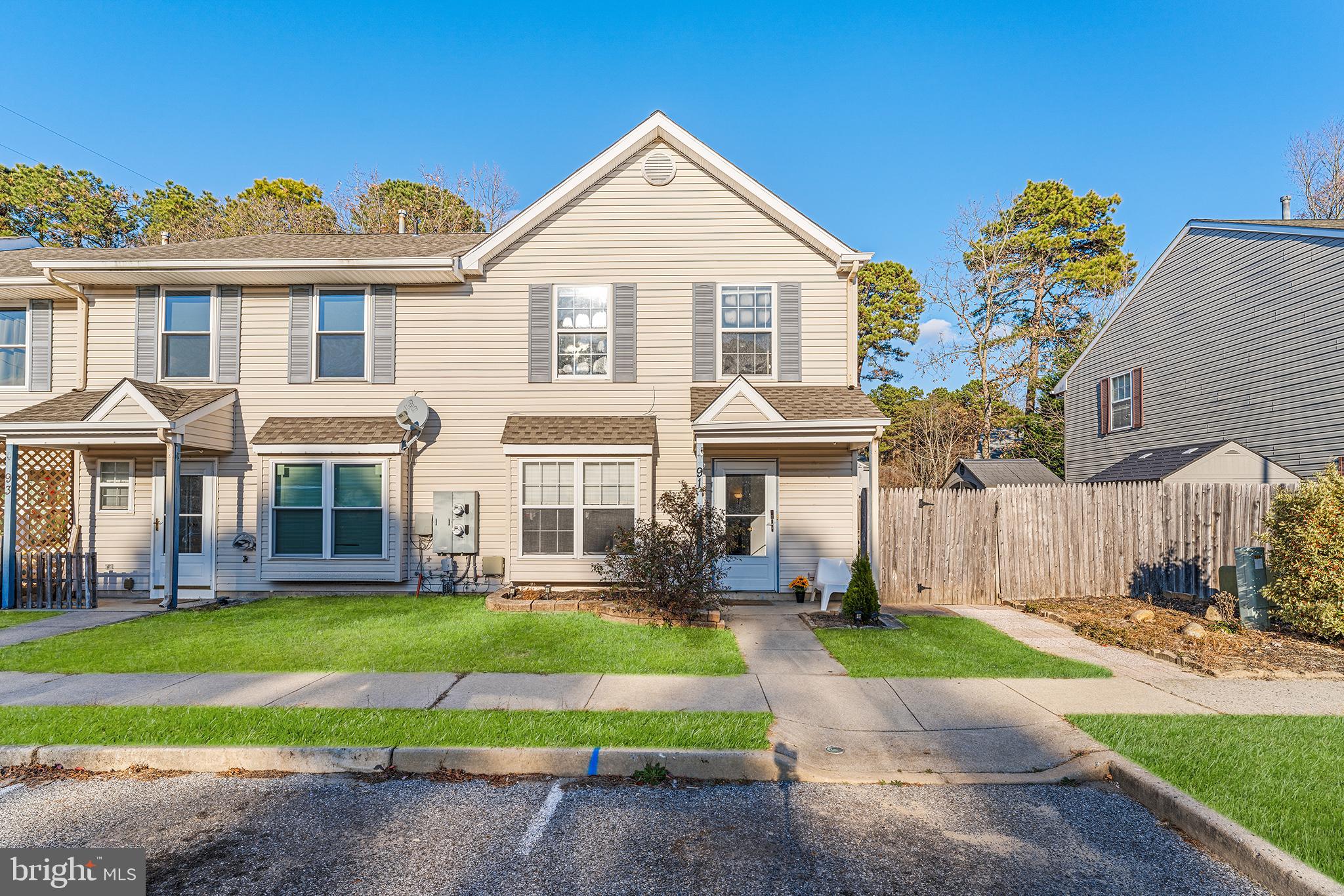 a front view of a house with a yard and potted plants