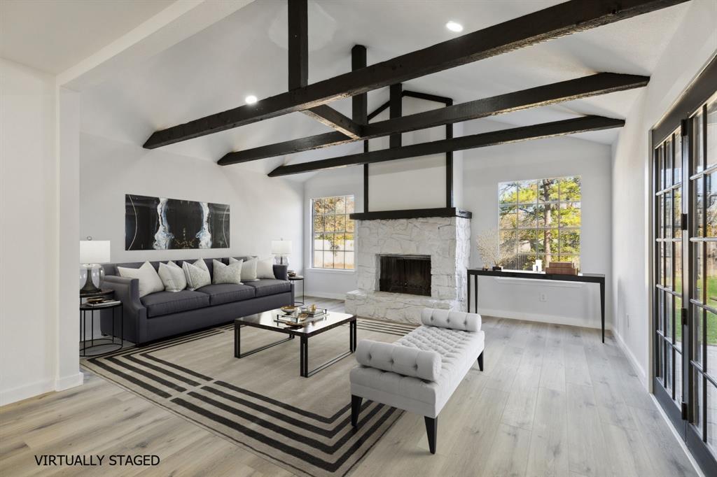 a living room with furniture a fireplace and a floor to ceiling window