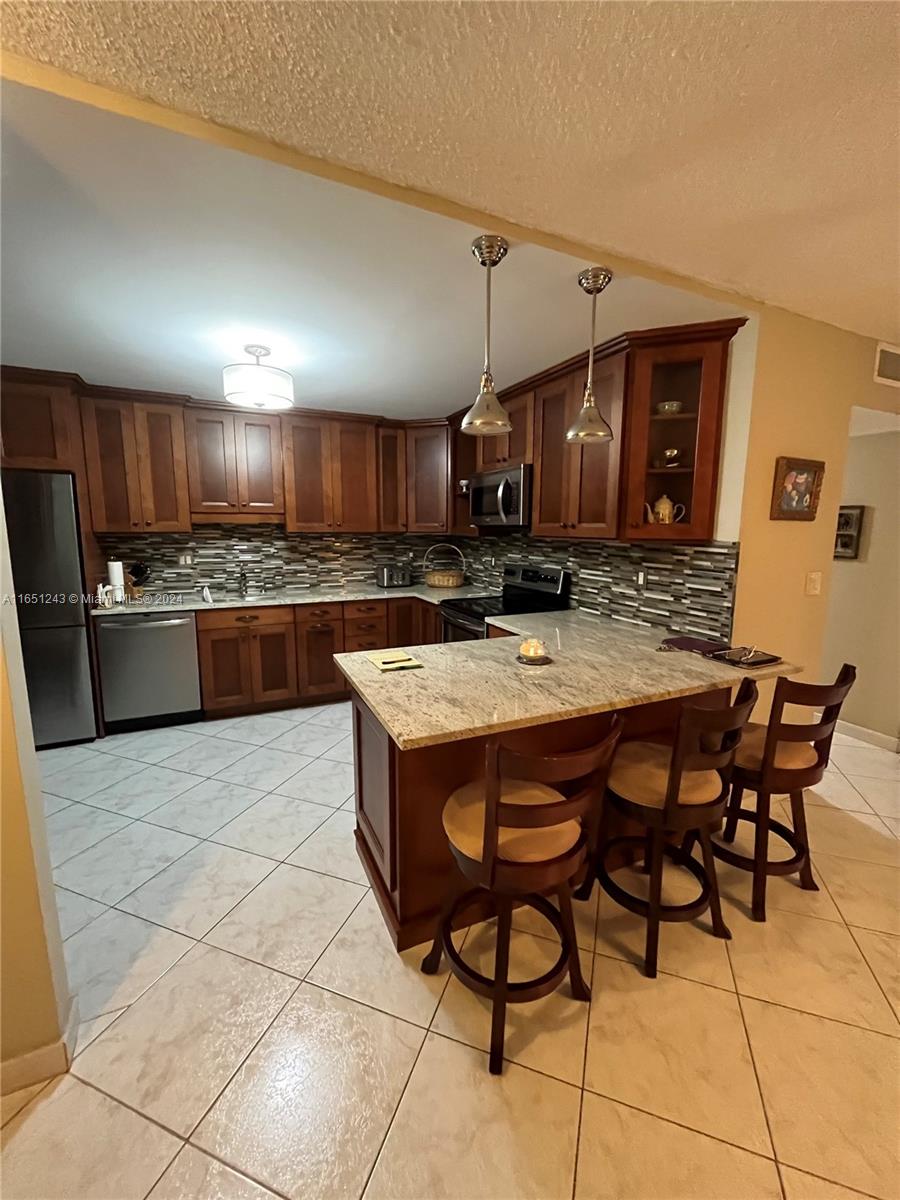 a kitchen with stainless steel appliances granite countertop a sink and a refrigerator