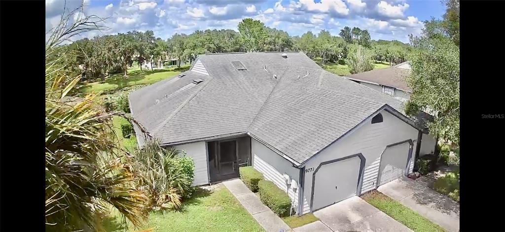 an aerial view of a house with a yard and potted plants