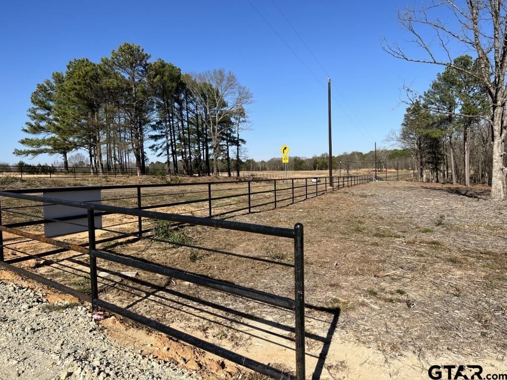 a view of a yard with wooden fence