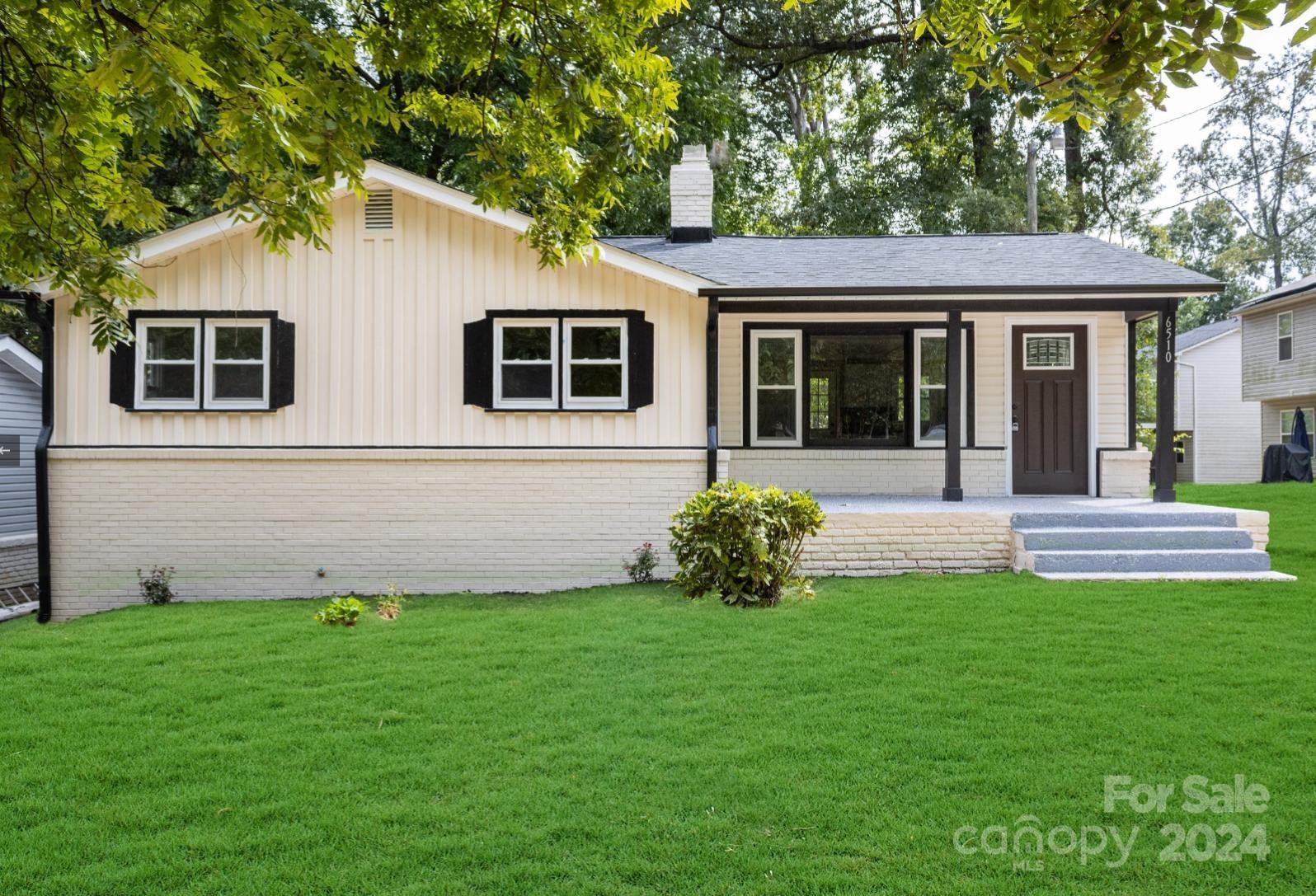 a front view of a house with a garden and yard