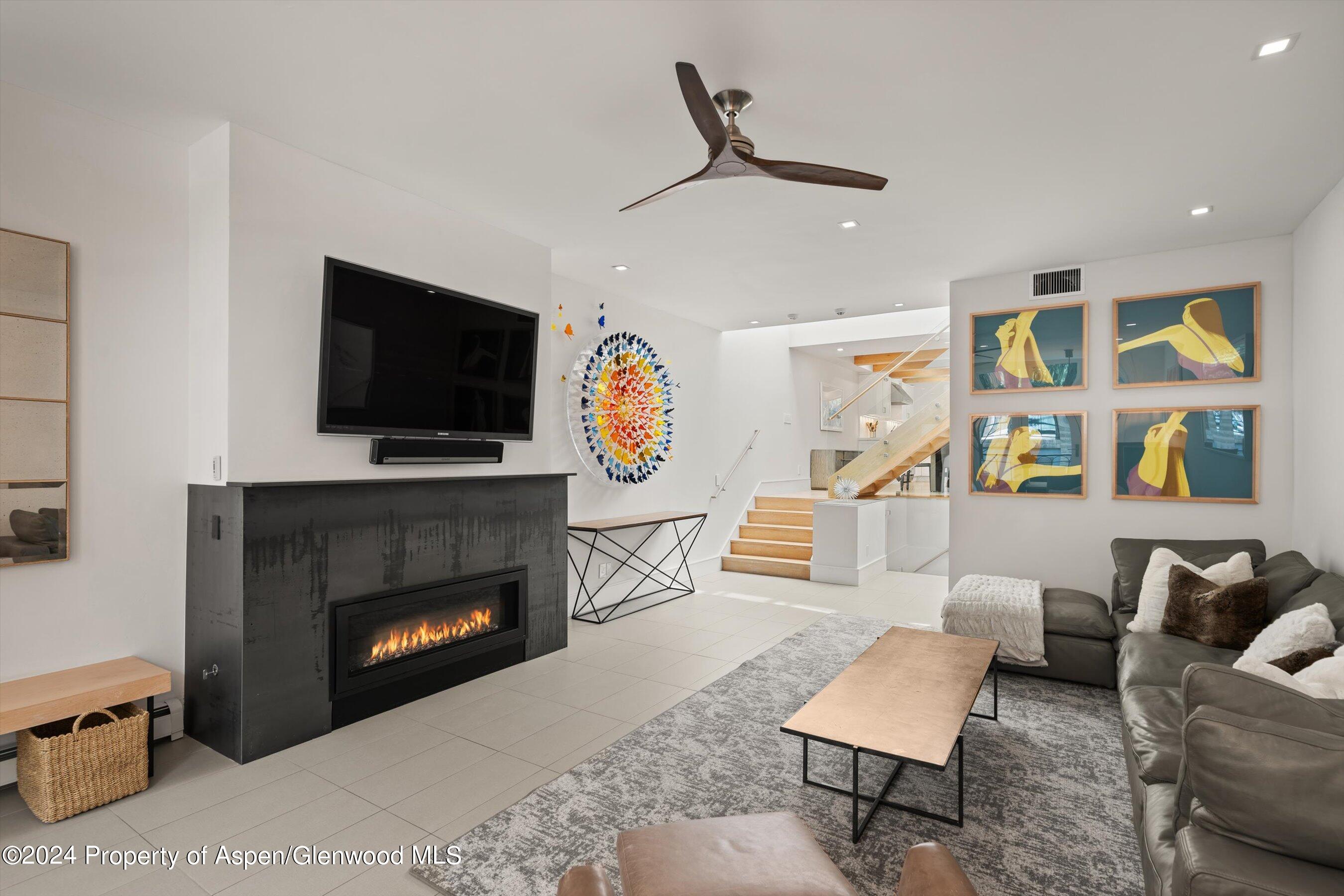 a living room with furniture a flat screen tv and a fireplace