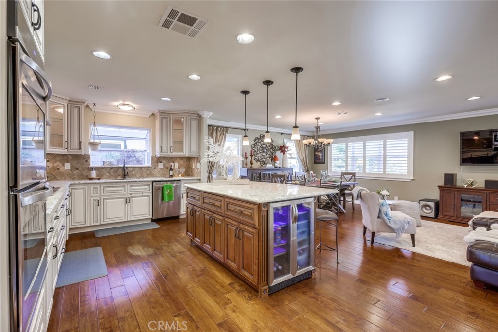 a large kitchen with stainless steel appliances granite countertop a large center island and a wooden floors