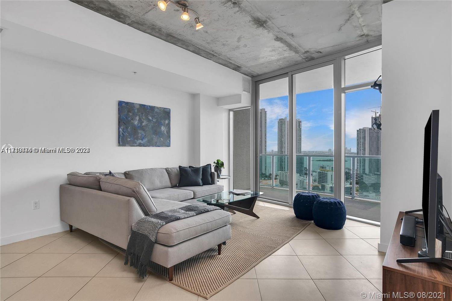 a living room with furniture a large window and a flat screen tv