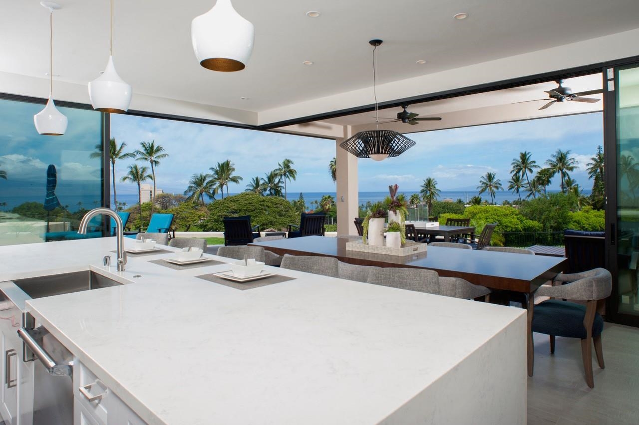 a view of open kitchen with dining table and chairs in it