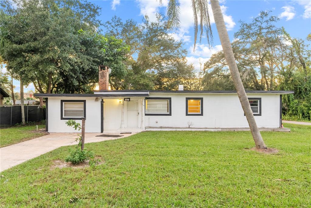 a view of a house with a backyard and a tree