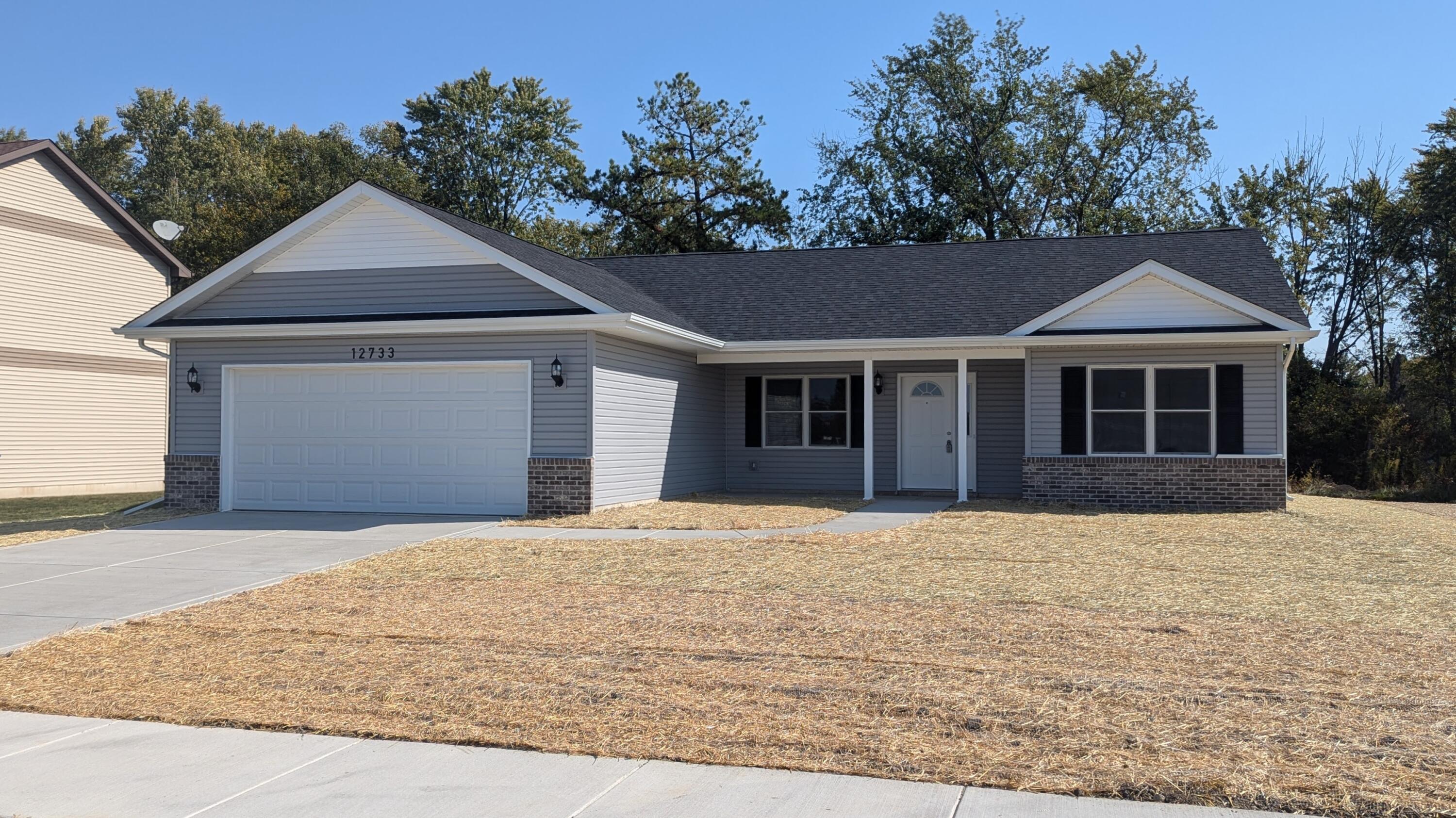 a front view of a house with a yard and trees