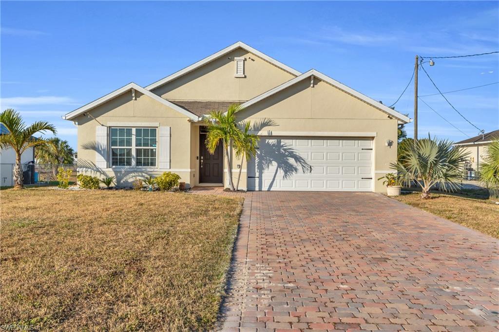 Ranch-style home featuring a front lawn and a garage