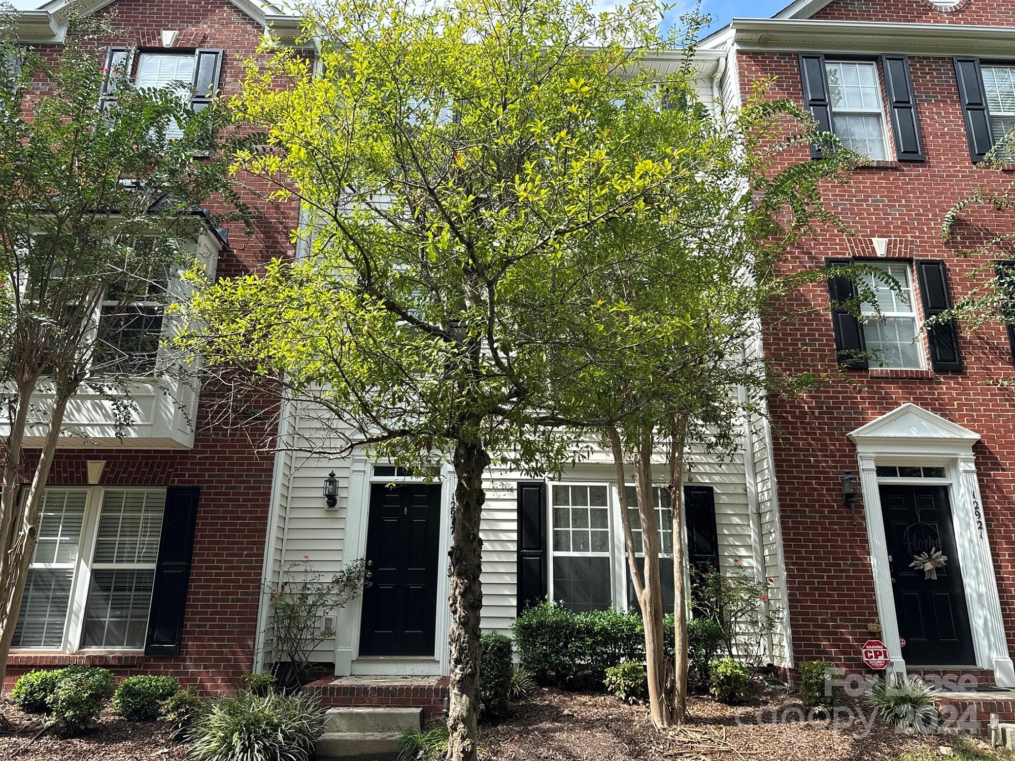 a front view of a house with a tree