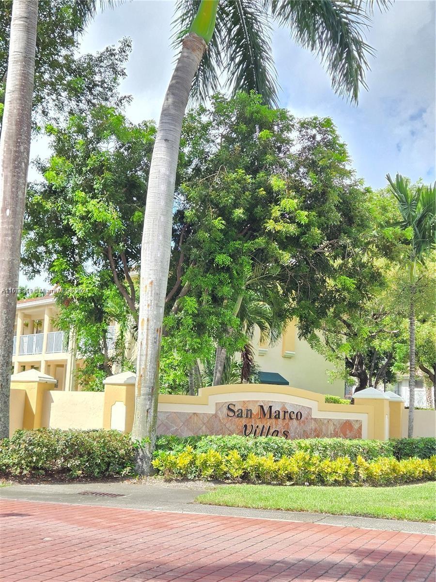 a front view of a house with a yard and potted plants