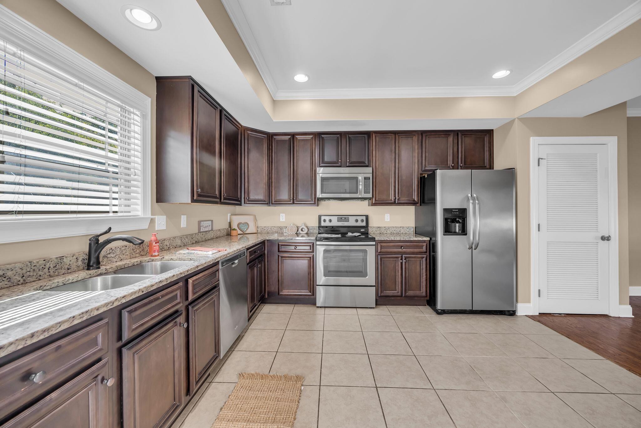 a kitchen with stainless steel appliances granite countertop a refrigerator and a sink