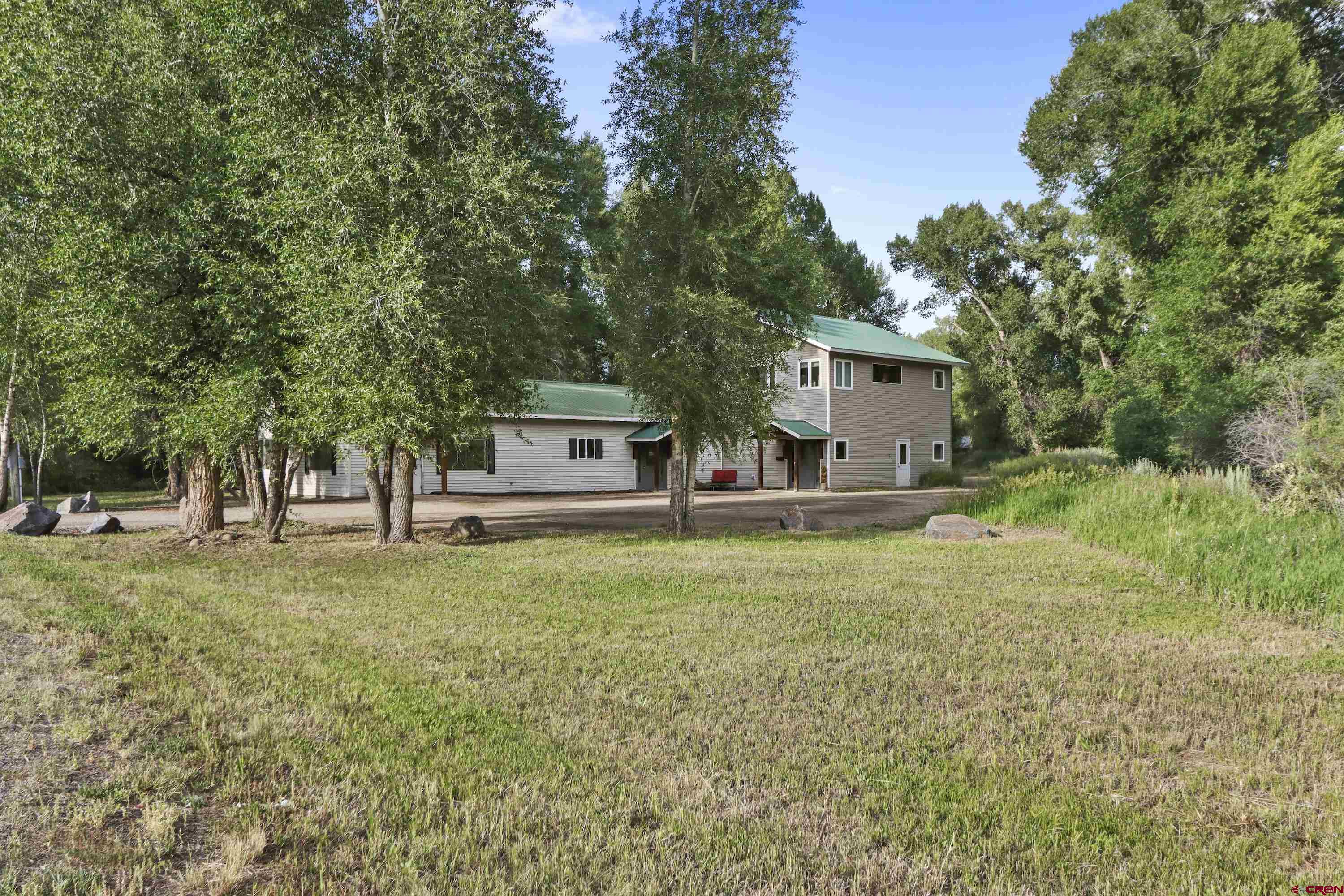 a front view of a house with a garden and trees