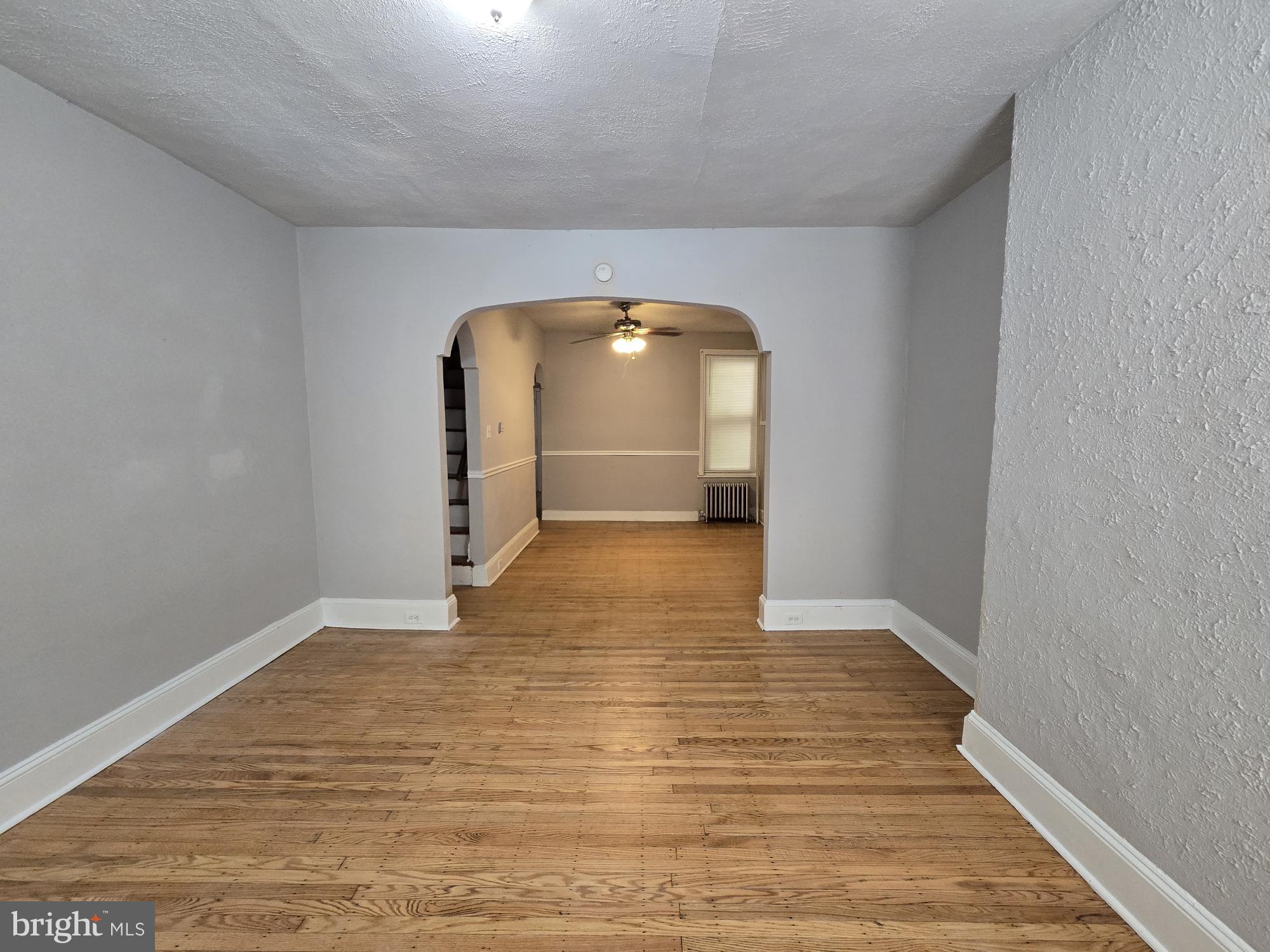 a view of empty room with wooden floor