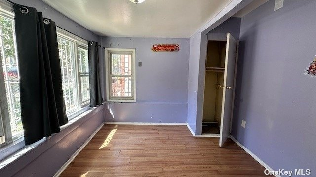 a view of a hallway with wooden floor and windows