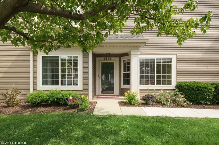 a front view of a house with a yard and potted plants