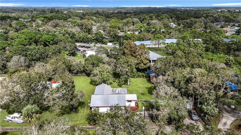 an aerial view of residential house with outdoor space and trees all around