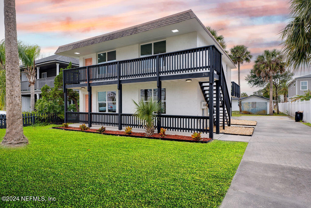 a view of a house with a yard and deck